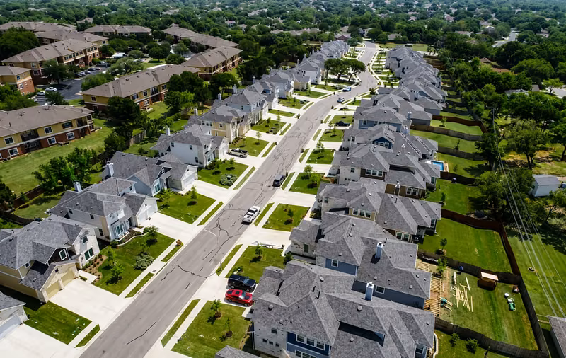 Aerial view of a planned residential community with manicured lawns and tree-lined streets