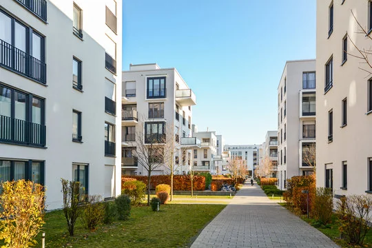 Modern apartment buildings around a landscaped central courtyard and walkway