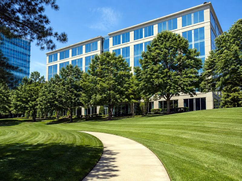 A freshly mowed, striped lawn and clean walkway at a maintained office property