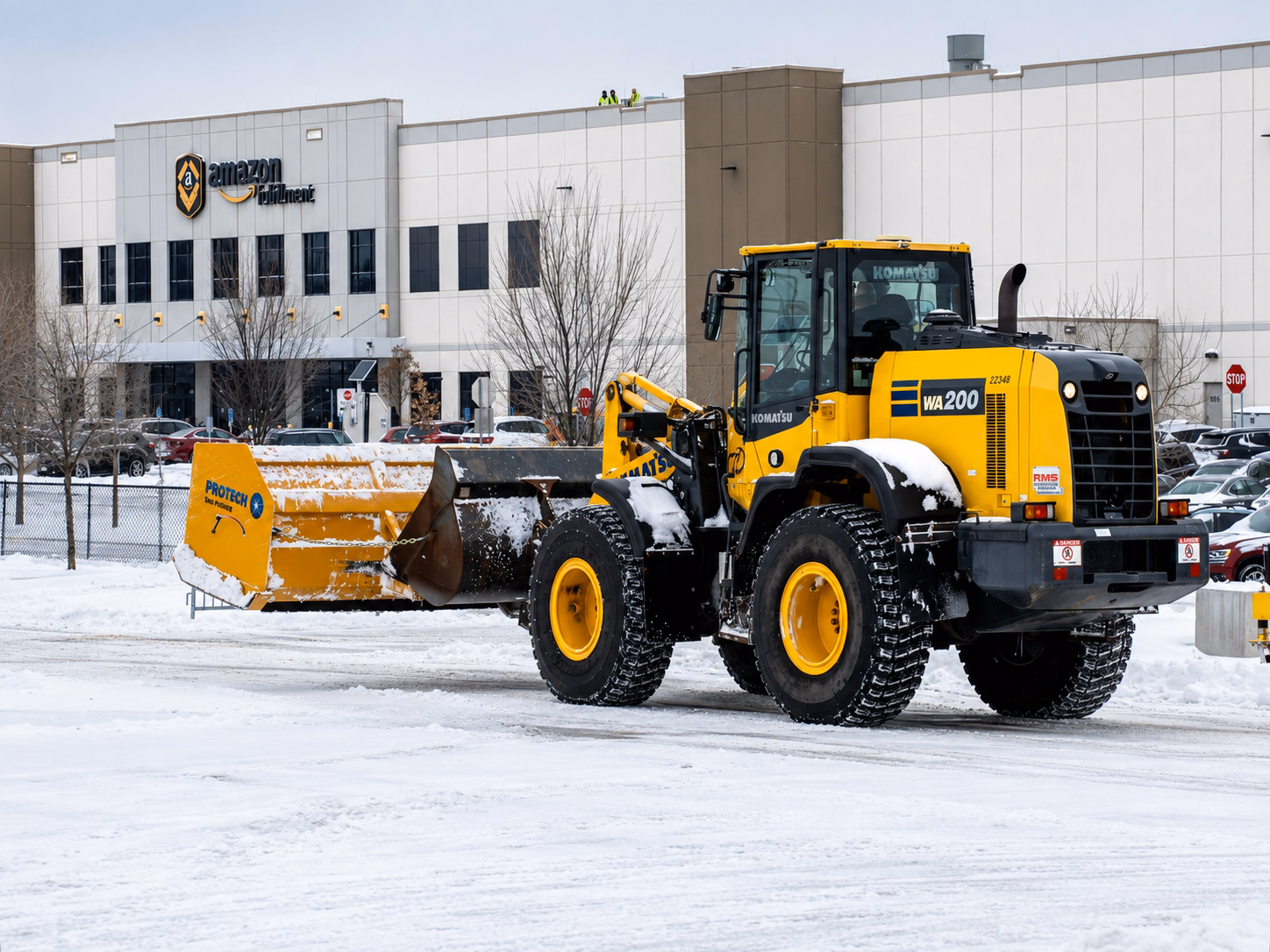 Wheel loader with a containment snow pusher clearing a distribution-center lot