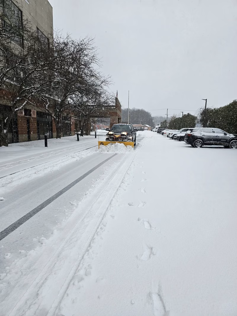 Terravian plow truck clearing a commercial lot during an active snowstorm